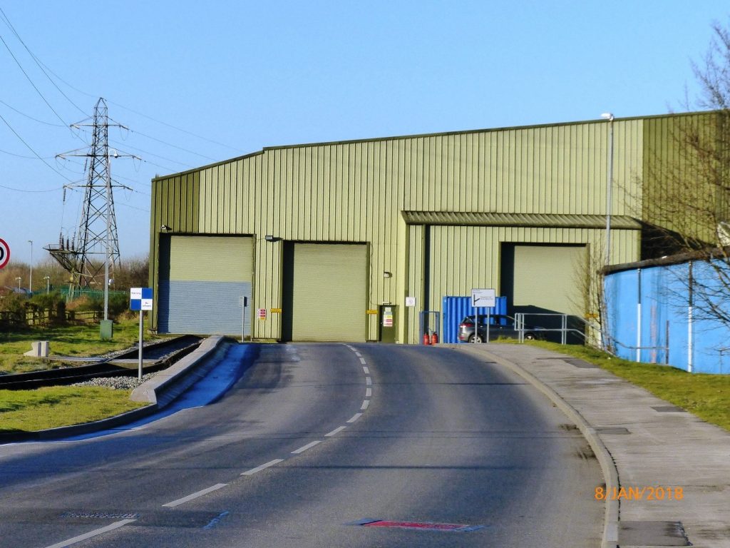 The rail line to the left, of the entrance to the warehouse