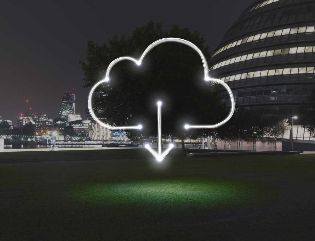 Glowing cloud symbol with download arrow in city at night